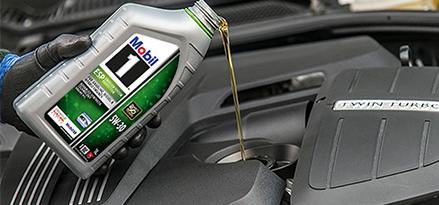 Mobil 1 oil being poured into car